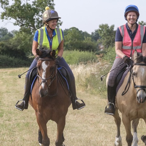 two smiling riders on horses
